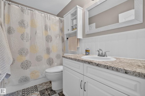 Vanity with integrated sink, speckled countertop, and white cabinetry - #25 200 Erin Ridge Dr, St. Albert, AB - Indoor Photo Showing Bathroom