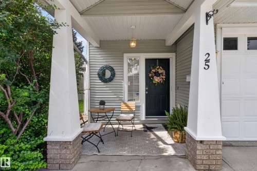 Covered porch with exposed aggregate concrete floor, white columns with brick bases, and a beadboard ceiling - #25 200 Erin Ridge Dr, St. Albert, AB - Outdoor