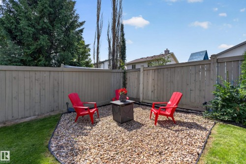 Gravel patio area with wood fence surround and surrounding lawn - #25 200 Erin Ridge Dr, St. Albert, AB - Outdoor