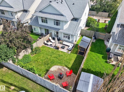 Expansive backyard retreat featuring a manicured lawn, mature landscaping with vibrant accent plantings, and defined hardscaped entertaining areas - #25 200 Erin Ridge Dr, St. Albert, AB - Outdoor
