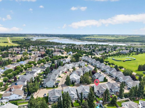 Aerial perspective of a residential neighborhood featuring established homes, mature trees, and a visible body of water - #25 200 Erin Ridge Dr, St. Albert, AB - Outdoor With View