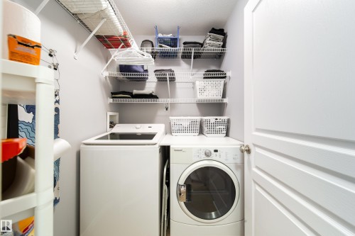 Laundry area featuring a top-load washing machine, front-load dryer, and wall-mounted wire shelving - 7239 21 Avenue Sw, Edmonton, AB - Indoor Photo Showing Laundry Room
