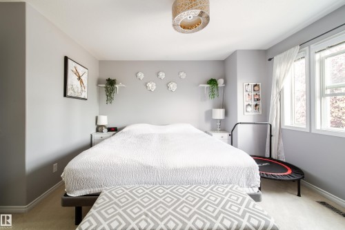 Recessed lighting, light gray wall color, textured ceiling, two large windows, and a decorative ceiling fixture - 7239 21 Avenue Sw, Edmonton, AB - Indoor Photo Showing Bedroom