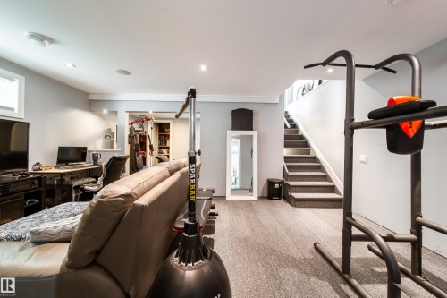 Finished lower level featuring recessed lighting, light gray walls, a carpeted staircase, and wood-finish flooring - 7239 21 Avenue Sw, Edmonton, AB - Indoor