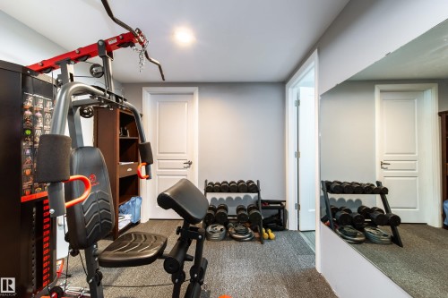 Dedicated fitness area with recessed lighting, light gray walls, textured gray carpet, and a full-height wall mirror - 7239 21 Avenue Sw, Edmonton, AB - Indoor Photo Showing Gym Room