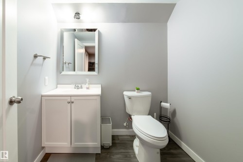 Renovated half bath featuring a white ceramic pedestal sink with chrome fixtures, mirrored medicine cabinet, and white subway tile walls - 7239 21 Avenue Sw, Edmonton, AB - Indoor Photo Showing Bathroom