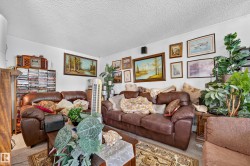 Living area with wall-mounted artwork, textured ceiling, and neutral wall color - 