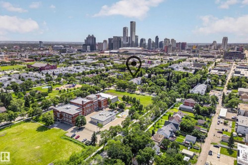 Aerial perspective showcasing a residential neighborhood with a prominent cityscape backdrop - #206 10842 107 St Nw, Edmonton, AB - Outdoor With View