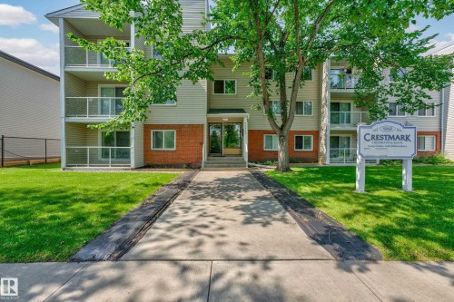 Multi-story residential building featuring light-colored siding and brick accents - #206 10842 107 St Nw, Edmonton, AB - Outdoor