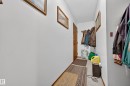 Entryway featuring a wood-panel door, coat hooks, and light-colored walls - #206 10842 107 St Nw, Edmonton, AB  - Indoor Photo Showing Other Room 