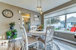 Dining area featuring wood-finish flooring and a contemporary multi-light pendant fixture - 