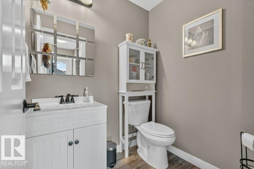 Bathroom featuring a white vanity with paneling and dark hardware, black faucet, and a wall-mounted mirror - 5322 Terwillegar Boulevard Nw, Edmonton, AB - Indoor Photo Showing Bathroom