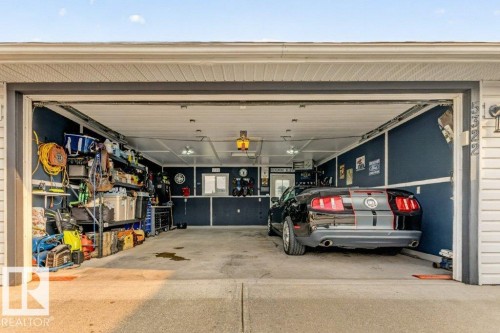 Two-car garage featuring dark blue wainscoting and light-colored upper walls - 5322 Terwillegar Boulevard Nw, Edmonton, AB -  Photo Showing Garage