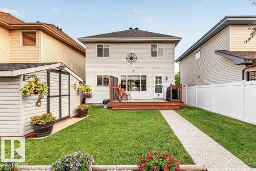 Expansive green lawn with a concrete pathway and a spacious wooden deck - 5322 Terwillegar Boulevard Nw, Edmonton, AB - Outdoor With Deck Patio Veranda With Exterior