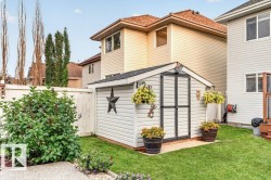 Backyard featuring a shed with double doors, a gabled roof, and white siding - 