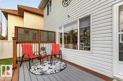Multi-level deck featuring composite decking, wood-finish railing with black balusters, and privacy lattice - 