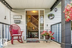 Covered front porch featuring light-colored siding, dark trim, and a concrete floor - 