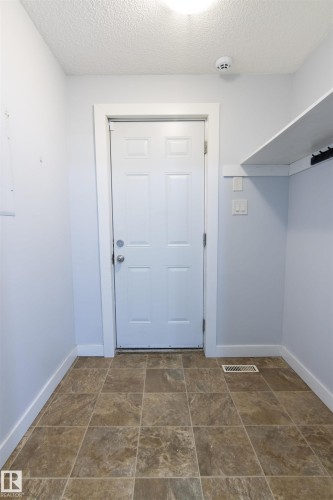 Doorway featuring a textured ceiling and stone finish floors - 11029 95 Street Nw, Edmonton, AB - Indoor Photo Showing Other Room