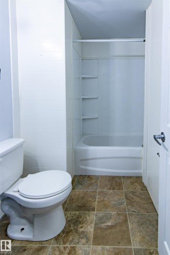 Full bath featuring shower / bath combination and stone finish flooring - 11029 95 Street Nw, Edmonton, AB - Indoor Photo Showing Bathroom