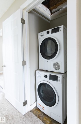Laundry room featuring stacked washer and clothes dryer - 11029 95 Street Nw, Edmonton, AB - Indoor Photo Showing Laundry Room