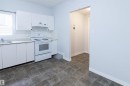Kitchen featuring white cabinets, electric stove, light countertops, under cabinet range hood, and backsplash - 11029 95 Street Nw, Edmonton, AB  - Indoor Photo Showing Kitchen 