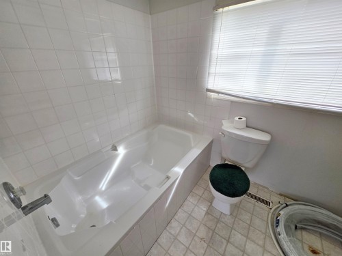 Bathroom featuring a vanity with an integrated sink and wood-finish detailing, an overhead mirror with medicine cabinet storage, and a shower with tiled walls - Rural St. Paul County, AB 