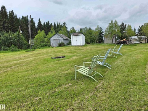 Expansive green space with distant tree lines, featuring two detached sheds - Rural St. Paul County, AB 