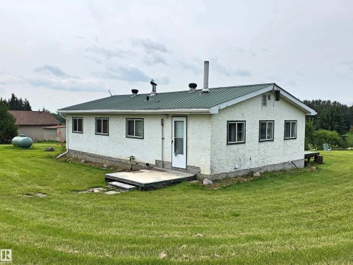 White stucco exterior, green metal roof, multiple windows & rear entry door - Rural St. Paul County, AB 