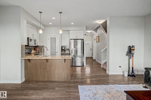 Kitchen with an island featuring a granite countertop and a stainless steel sink - 1783 Keene Crescent Sw, Edmonton, AB - Indoor Photo Showing Kitchen With Upgraded Kitchen