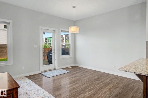 Wood-finish flooring, white trim, and a pendant light fixture - 1783 Keene Crescent Sw, Edmonton, AB - Indoor