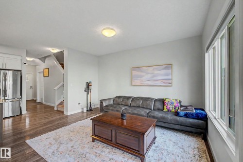 Wood-finish flooring, white trim, recessed lighting, and a large window - 1783 Keene Crescent Sw, Edmonton, AB - Indoor Photo Showing Living Room
