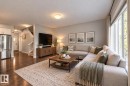 Open-concept living area featuring wood-finish flooring, recessed lighting, and large windows - 1783 Keene Crescent Sw, Edmonton, AB 