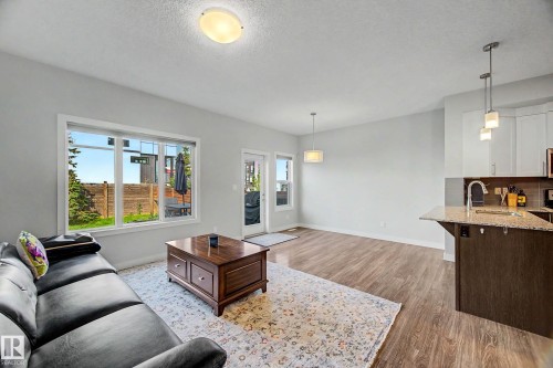 Wood-finish flooring, recessed lighting, and a kitchen island with a granite-style countertop - 1783 Keene Crescent Sw, Edmonton, AB - Indoor Photo Showing Living Room
