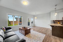 Wood-finish flooring, recessed lighting, and a kitchen island with a granite-style countertop - 