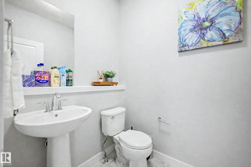 Pedestal sink with chrome fixtures and a wall-mounted mirror - 1783 Keene Crescent Sw, Edmonton, AB - Indoor Photo Showing Bathroom