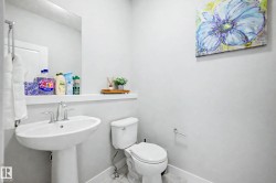 Pedestal sink with chrome fixtures and a wall-mounted mirror - 