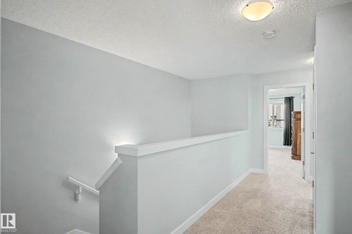 Carpeted hallway with painted walls and a flush-mount ceiling light - 1783 Keene Crescent Sw, Edmonton, AB - Indoor Photo Showing Other Room