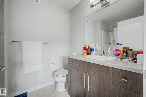 Bathroom featuring a vanity with dark wood-finish cabinetry, a single basin sink, and a framed mirror - 1783 Keene Crescent Sw, Edmonton, AB - Indoor Photo Showing Bathroom