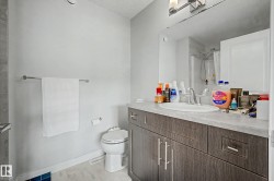 Bathroom featuring a vanity with dark wood-finish cabinetry, a single basin sink, and a framed mirror - 