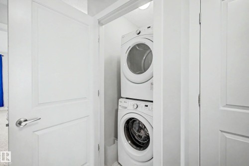 Integrated laundry closet with stacked appliances - 1783 Keene Crescent Sw, Edmonton, AB - Indoor Photo Showing Laundry Room