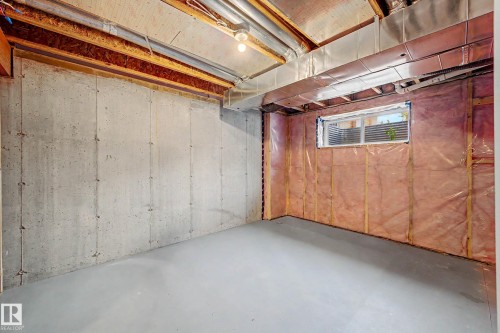 Spacious garage with polished concrete flooring, exposed wooden beam ceiling structure, and high-bay lighting - 1783 Keene Crescent Sw, Edmonton, AB - Indoor Photo Showing Basement