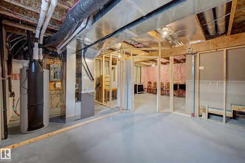 Unfinished basement space featuring exposed ductwork, structural framing, and a water heater, offering customization potential - 1783 Keene Crescent Sw, Edmonton, AB - Indoor Photo Showing Basement