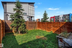 Private backyard oasis featuring mature landscaping, lush lawn, and cedar wood-finish privacy fencing - 