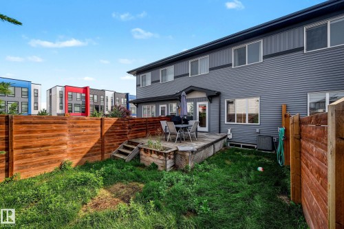 Private wooden fence encompassing the backyard, an elevated wooden deck, and a multi-story exterior with horizontal siding - 1783 Keene Crescent Sw, Edmonton, AB - Outdoor With Exterior