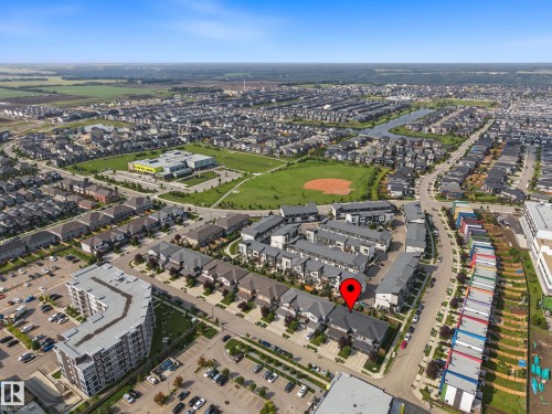 Residential neighborhood featuring a mix of detached homes and townhouses, with a prominent community green space and a large body of water - 1783 Keene Crescent Sw, Edmonton, AB - Outdoor With View