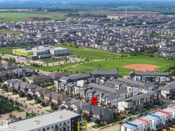 Aerial perspective showcasing a residential community with varied architectural styles, green spaces, and a school building - 