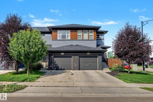 Two-story residence featuring a two-car garage, stone facade accents, and horizontal siding - 1783 Keene Crescent Sw, Edmonton, AB - Outdoor With Facade