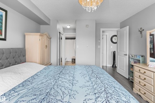 Recessed lighting, wood-finish flooring, and a crystal chandelier - #305A 6 Spruce Ridge Dr, Spruce Grove, AB - Indoor Photo Showing Bedroom