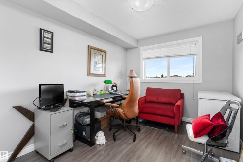 Modern home office featuring a dedicated workspace with a black desk, ergonomic task chair, and ample natural light from a large window - #305A 6 Spruce Ridge Dr, Spruce Grove, AB - Indoor Photo Showing Office