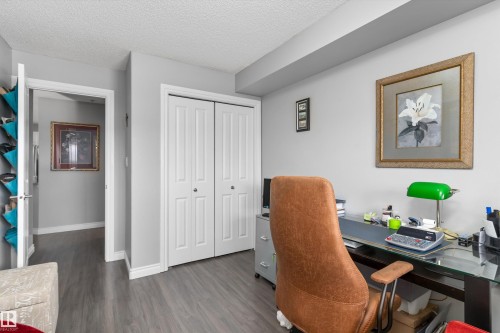 Gray walls, wood-finish flooring, white trim, and a white bi-fold closet door - #305A 6 Spruce Ridge Dr, Spruce Grove, AB - Indoor Photo Showing Office